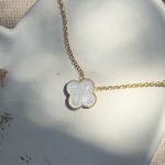 Pozłacany naszyjnik z białą koniczynką kwiatkiem, wykonany ze srebra próby 925 pokryty 24-karatowym złotem